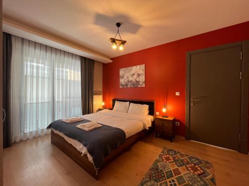 1 dormitorio con cama y pared roja en cozy unique flat hGyHomes1107 close to the memoriall hospital at the city center, en Estambul