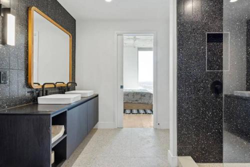 y baño con 2 lavabos, espejo y ducha. en Luxury 1BR - Rainey St - Top Amenities - RoofTop Pool - 11th Floor, en Austin