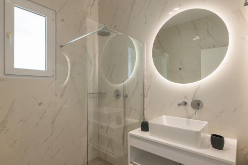 a white bathroom with a sink and a mirror at Island Hills in Rhodes Town