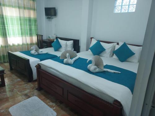 two beds in a bedroom with two pillows on them at Ella Zenith View in Ella