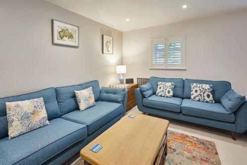 a living room with two blue couches and a table at Host & Stay - Breckon Cottage in Whitby
