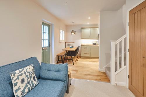 a living room with a blue couch and a kitchen at Host & Stay - Breckon Cottage in Whitby