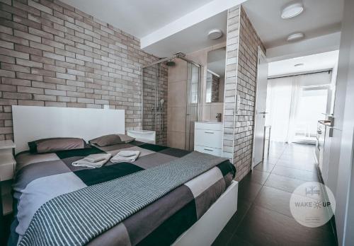 um quarto com uma cama grande e uma parede de tijolos em WakeUp Esch-City em Esch-sur-Alzette