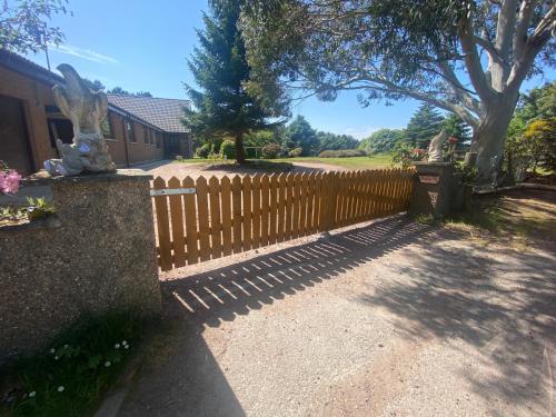 a wooden fence in front of a house at Drummond House - Pets welcome free, 3 acres of gardens, free parking in Brackley