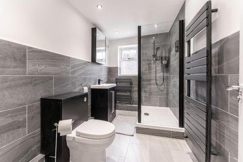 a bathroom with a toilet and a shower and a tub at Tanna Estates - Ranelagh Terrace House in Leamington Spa