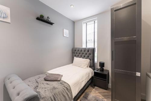 - une petite chambre avec un lit et un canapé dans l'établissement Tanna Estates - Ranelagh Terrace House, à Leamington Spa