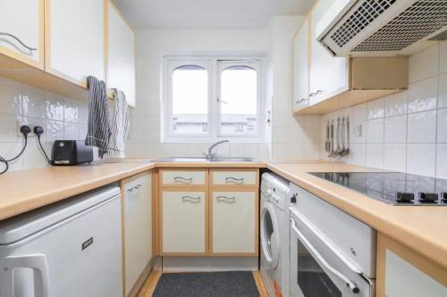 una cucina con lavandino e lavastoviglie di 1BD Flat - Prime Location Surrey Quays a Londra