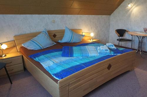 een slaapkamer met een groot houten bed met blauwe lakens bij Ferienhof Zum Rössberg in Geisa