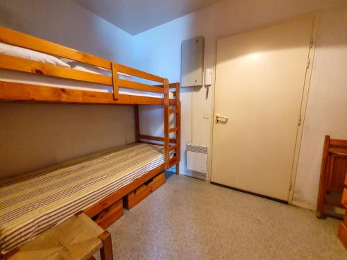 Cette chambre comprend 2 lits superposés et une porte. dans l'établissement POINT D'OR - L'océan à vos pieds, T1 bis pour 4 personnes, à Soorts-Hossegor