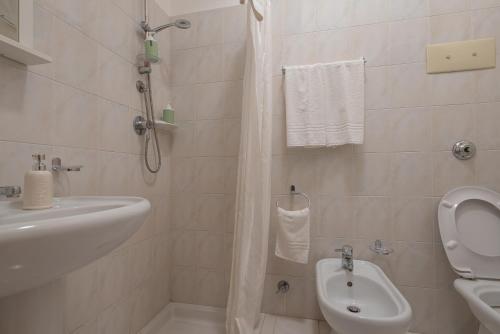 uma casa de banho com um lavatório, um WC e um chuveiro em Appartamentino House numero 119 em Piraino