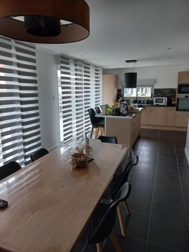 une cuisine avec une grande table et des chaises en bois dans l'établissement Magnifique maison à 5 mns du circuit des 24h à pieds, au Mans