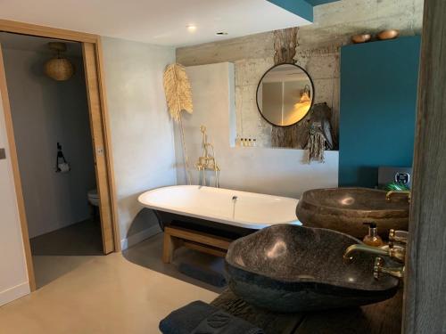 ein Badezimmer mit einer Badewanne und einem Waschbecken in der Unterkunft La Cambrousse 