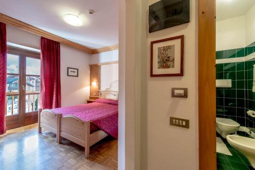 a bedroom with a bed and a bathroom at Park Hotel Sport in Andalo