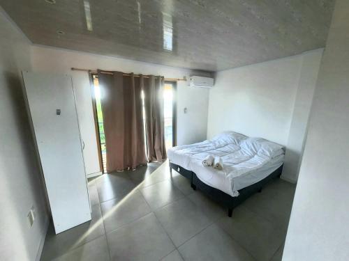 - une chambre avec un lit et une grande fenêtre dans l'établissement Posada El Mariscal, à Paso de los Toros