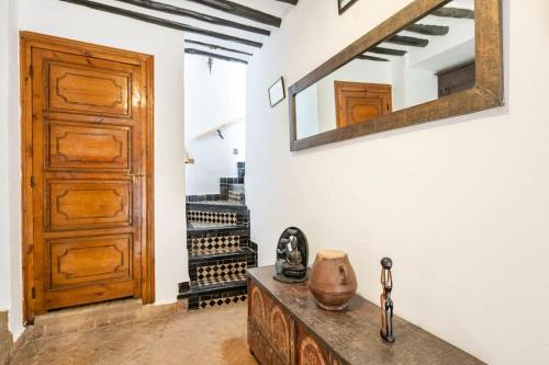 Habitación con puerta de madera y mesa con espejo. en RIAD ALGHANI en Marrakech