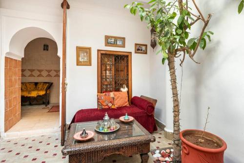 sala de estar con sofá rojo y mesa en RIAD ALGHANI en Marrakech