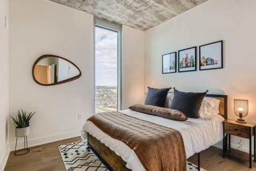 um quarto com uma cama e uma grande janela em Incredible View Of Downtown Walk To Rainey St em Austin