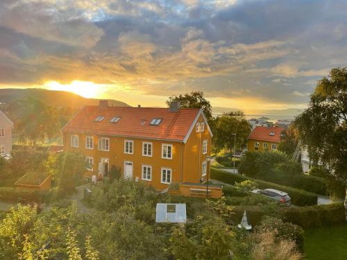 an orange house with the sunset in the background at Tomannsbolig på Rosenborg in Trondheim