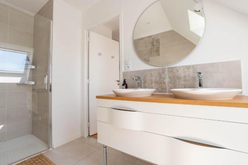 une salle de bain avec deux lavabos et un miroir dans l'établissement Banana Beach - Magnifique Villa contemporaine vue mer plage à 20 m avec paddles, à Sarzeau