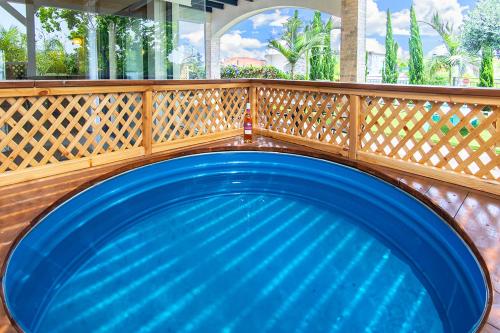 a blue swimming pool with a wooden fence at Mother Nature - Gilboa in H̱efẕi Bah