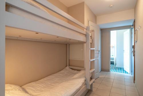 a bedroom with two bunk beds and a balcony at Les Thermes 521 - Appt proche plage avec piscine partagée in Concarneau