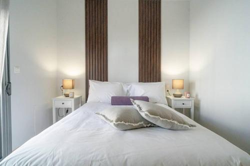 a bedroom with a white bed with two night stands at #T33 Chic 2BR apartment in the centre of Volos in Volos