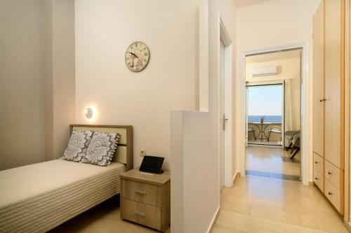 a bedroom with a bed and a clock on the wall at Nissaki Bay in Nisakion