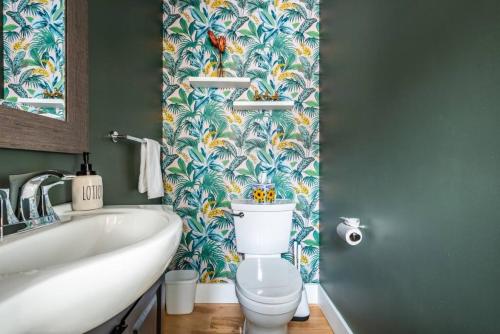 baño con aseo y papel pintado tropical en Modern Fishtown Townhouse, en Filadelfia