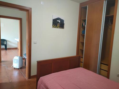 a bedroom with a bed with a pink bedspread at Casa dos Avós 2 in São Roque do Pico