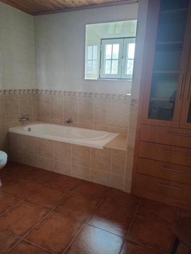 a bathroom with a bath tub and a window at Casa dos Avós 2 in São Roque do Pico