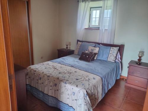 Un dormitorio con una cama con dos bolsas. en Casa dos Avós en São Roque do Pico