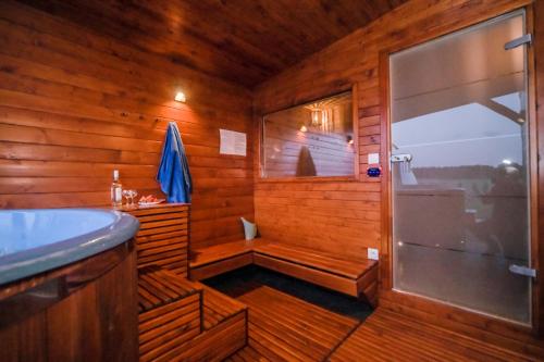 a wooden bathroom with a shower and a sink at ZACISZE W OGRÓDKU Dom z balią i sauną in Ogródek
