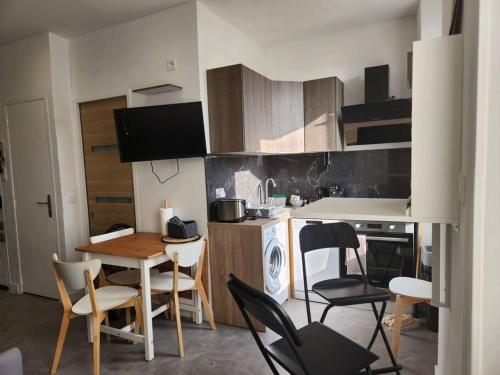 une cuisine avec une table et des chaises dans une pièce dans l'établissement Le panier de papet,central, proche plage catalan,tres calme,vue, à Marseille