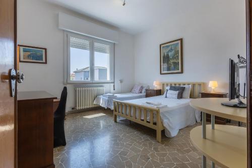 sypialnia z 2 łóżkami, stołem i oknem w obiekcie Cà Fernanda w mieście Fiesso Umbertiano