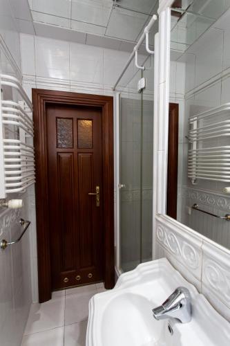 a bathroom with a sink and a mirror and a door at Центр. Вулиця Липова. 3 кімнати in Ternopilʼ