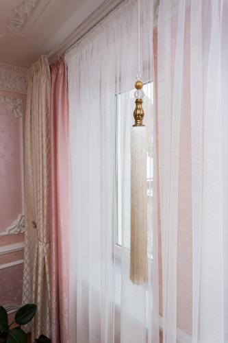 a room with a window with curtains and a chandelier at Центр. Вулиця Липова. 3 кімнати in Ternopilʼ