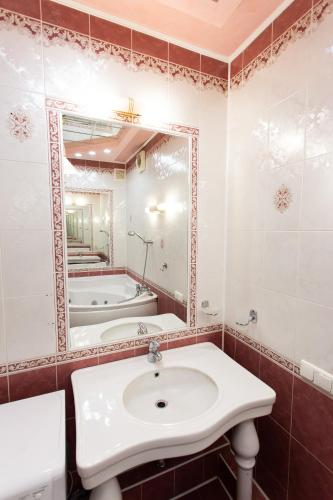 a bathroom with a sink and a tub and a mirror at Центр. Вулиця Липова. 3 кімнати in Ternopilʼ