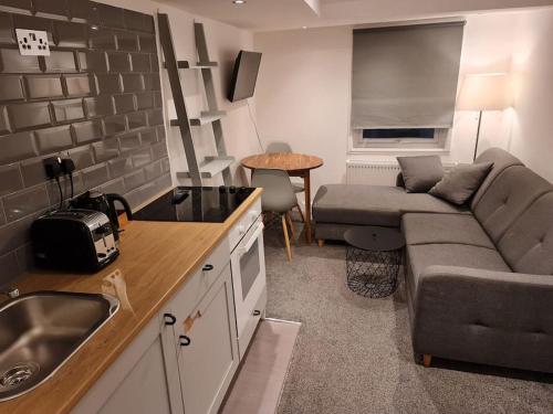 uma pequena cozinha e sala de estar com um sofá em Top floor Warren st flat. em Londres