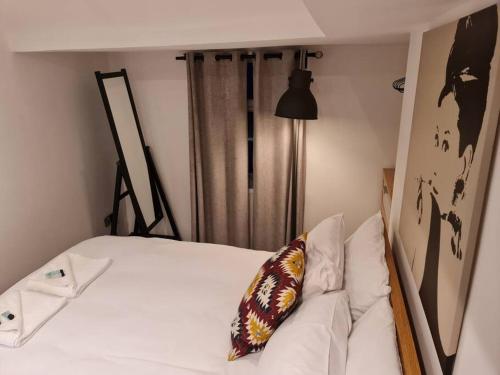 uma cama branca com uma almofada em cima em Top floor Warren st flat. em Londres