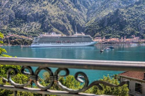 a cruise ship in a body of water with mountains at Apartments Dončić in Kotor