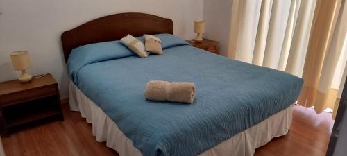 a bedroom with a bed with two towels on it at Casa Cómoda en La Cruz Quillota in La Cruz