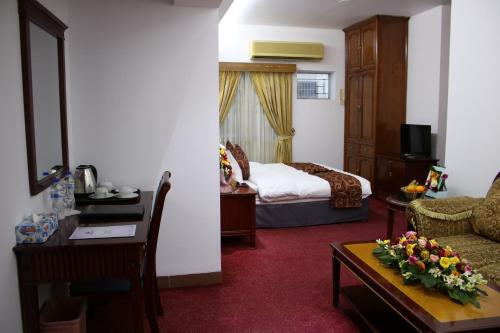 a hotel room with a bed and a living room at Hotel West Valley Dhaka in Dhaka