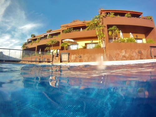 a hotel with a swimming pool in front of a building at Chijere Faro del Inglés in Valle Gran Rey