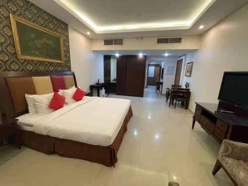 a bedroom with a bed and a flat screen tv at Clifton International Hotel in Fujairah