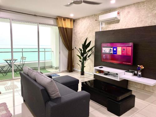 a living room with a tv and a couch and chairs at Mansion One Suite by stayCATion Homestay in George Town
