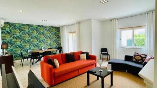 sala de estar con sofá naranja y mesa en Balaia Prestige by Check-in Portugal en Albufeira