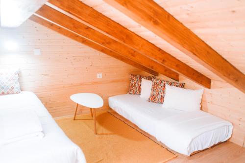 a attic room with a bed and a table at Casita do Castelo in Lourinhã
