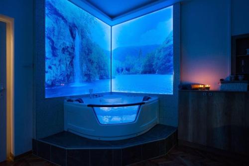 a bathroom with a tub with a large window at Hedonist-Belgrade Central Nest in Belgrade