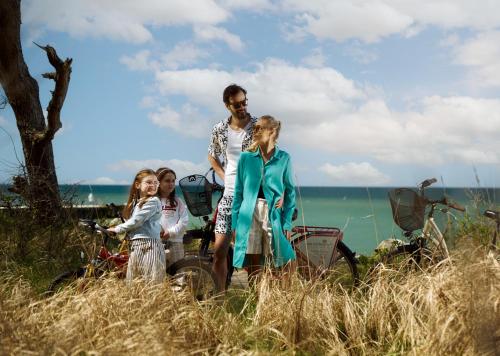 a family standing in the grass near the ocean at Arka Medical Spa in Kołobrzeg