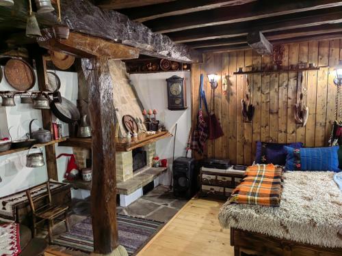 a room with a fireplace and a bed in it at Къща за гости КИМ in Apriltsi